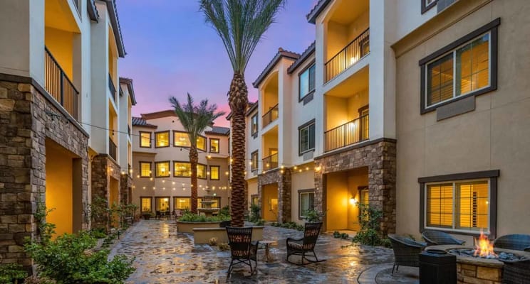 Evening view of the courtyard with palm trees and string lights