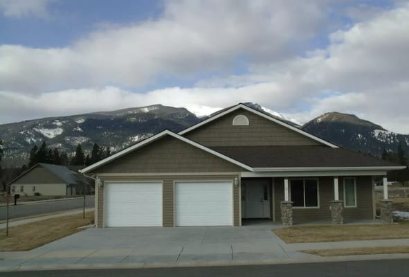 Front view of a house at Kootenai Creek Village with mountains in the background
