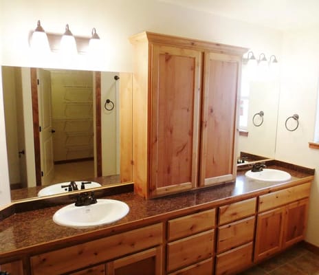 Spacious bathroom with dual sinks and wooden cabinets