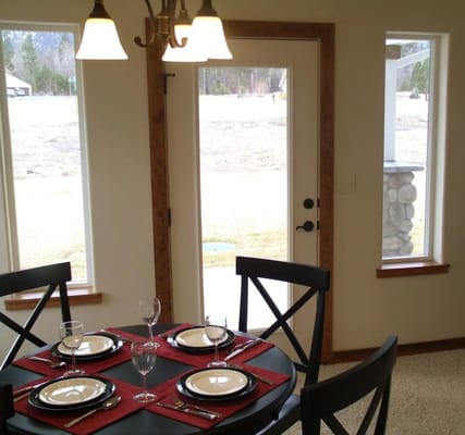 Table set for dining in a bright room with large windows