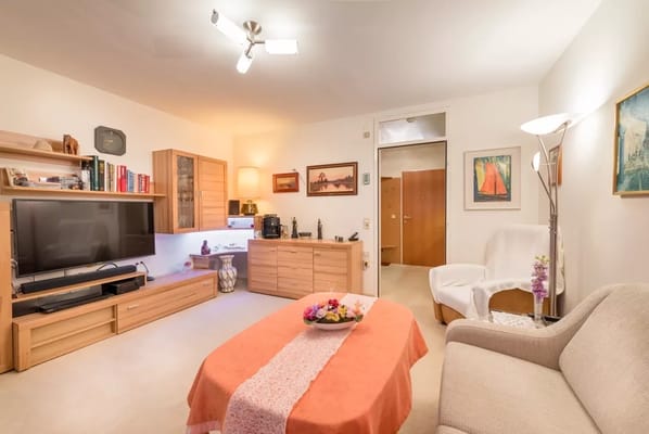 Living room interior with orange tablecloth and TV setup