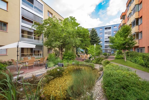 Garden area with pond and seating at a senior living facility