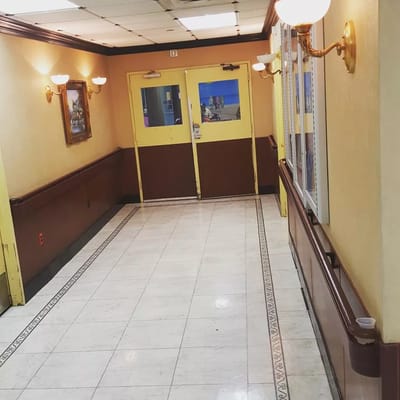 Interior hallway with yellow doors and wall sconces