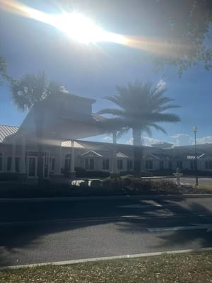Exterior view of a senior living facility with palm trees