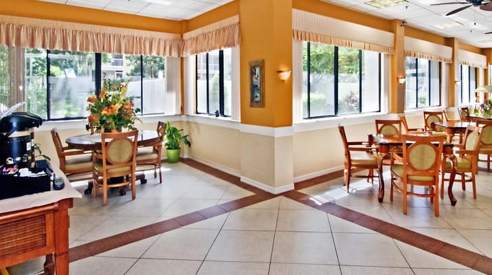 Bright dining area with large windows and floral decorations