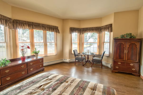 Spacious bedroom with windows and a cozy sitting area.
