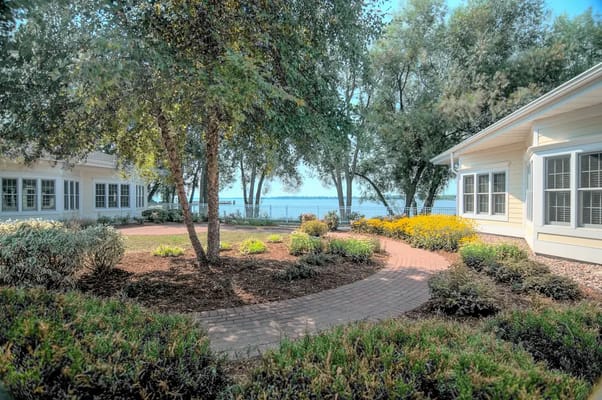 A winding path through a landscaped garden at Lakeshore Manor overlooking the water.