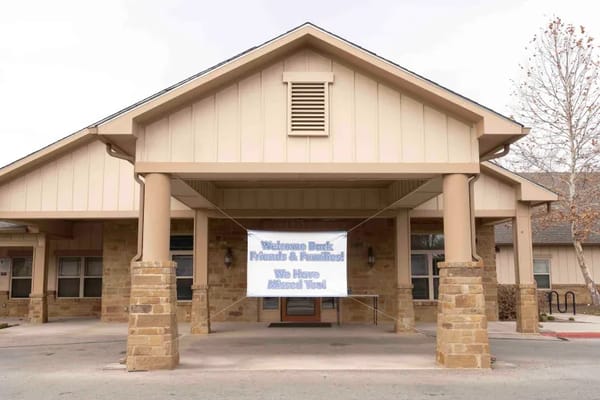 Exterior view of the nursing home building with a welcome banner