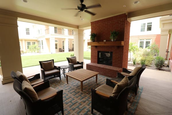 Outdoor seating area with a fireplace and comfortable chairs