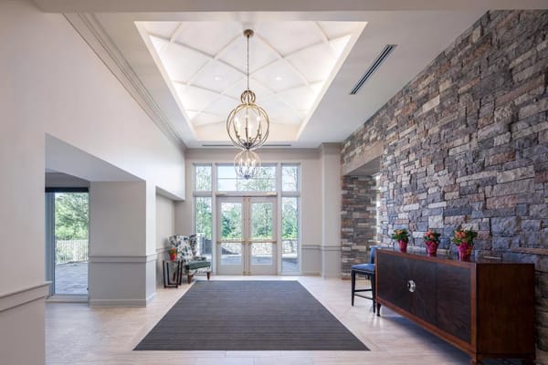 Lobby area with a chandelier and stone wall