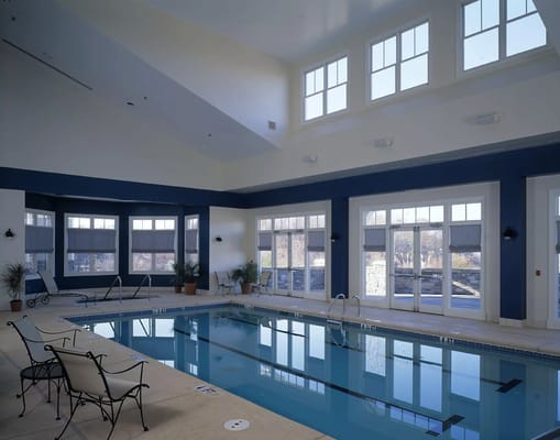 Indoor pool area with natural light and seating