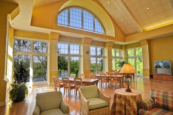 Lounge area with large windows, seating, and a dining table.