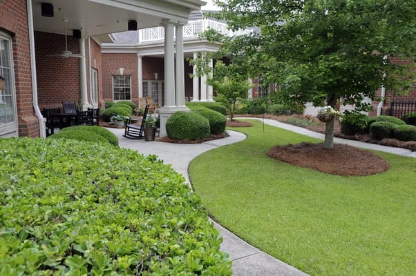 Scenic garden path with greenery and rocking chairs