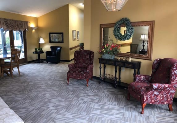 Cozy common area with floral chairs and a mirror