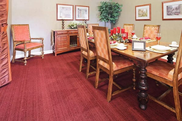 A dining room with a wooden table set for dinner, featuring chairs and decor.
