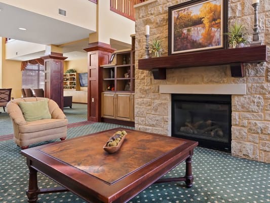 Interior view of a cozy common area with a fireplace and seating.