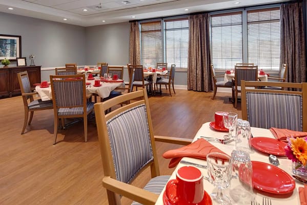 Dining room set for a meal with red table settings