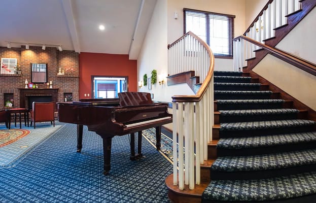 Lobby featuring a grand piano and staircase.