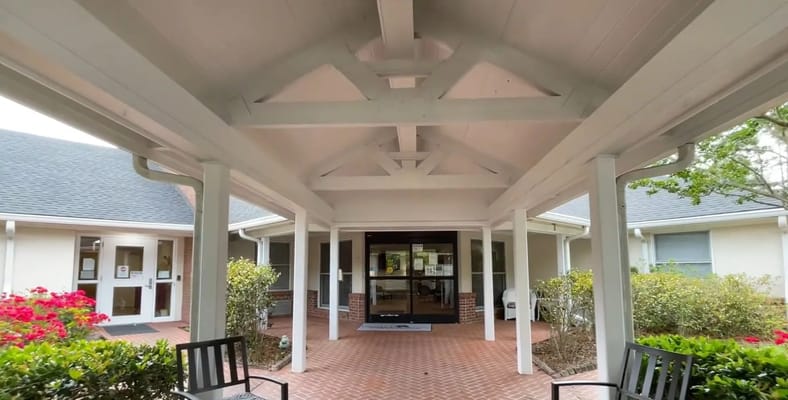 Covered entrance with seating and landscaping at Liberty Commons