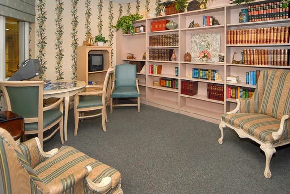 A cozy library area with bookshelves, a table, and chairs.