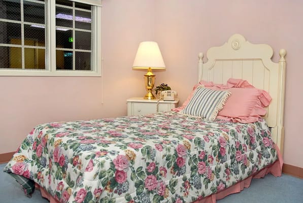 Bright bedroom with floral bedding and a lamp