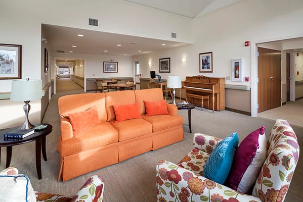 Bright and welcoming living room with orange sofa and colorful chairs