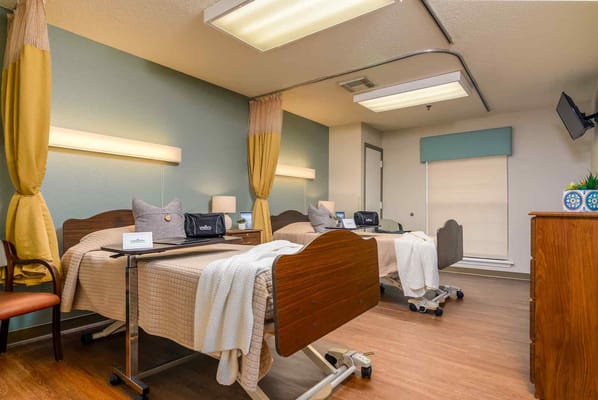 A shared room with two beds and personal items in Longview Hill Nursing Center.