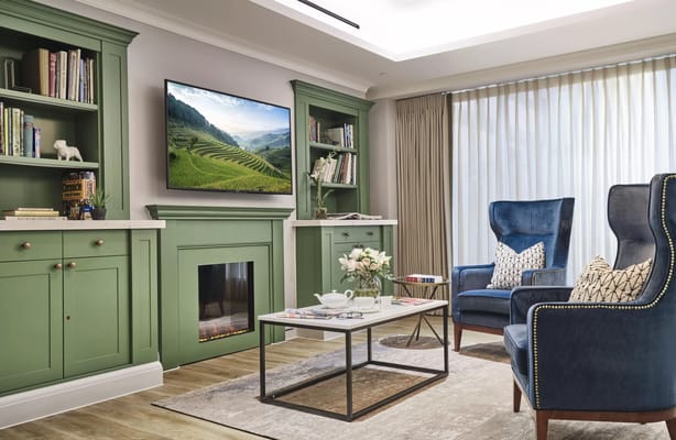 A cozy common area with green cabinets and seating