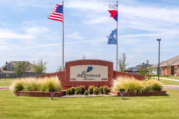 Entrance sign of Lyndale Abilene Senior Living with flags