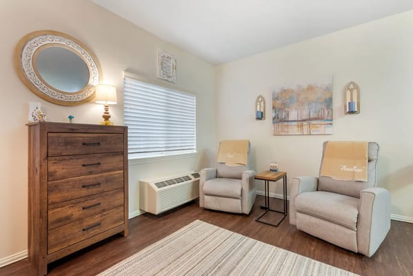 Cozy interior living area with two recliners and a dresser
