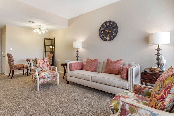Comfortable living room with colorful chairs and a sofa.