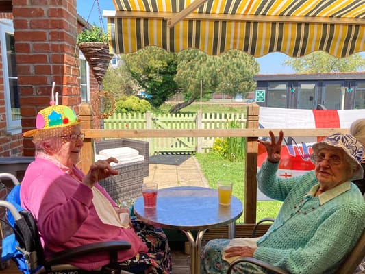 Two residents enjoying drinks on a sunny patio