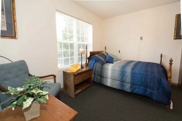 A private resident room with a bed and seating area