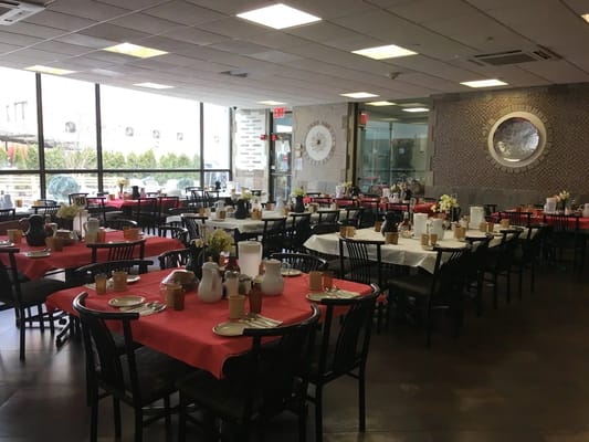 Dining room with tables set for meals at Madison York Assisted Living
