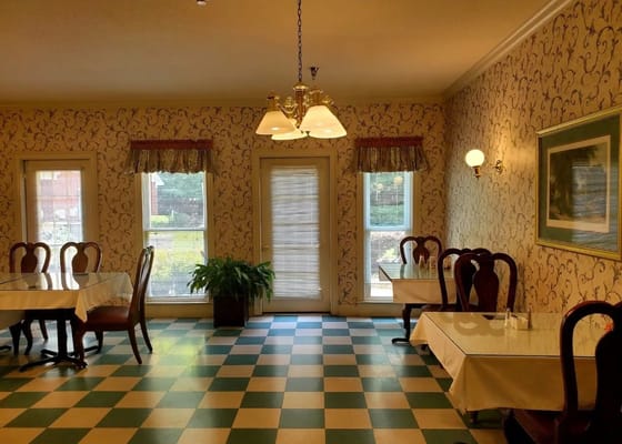 Dining area with tables and patterned wallpaper