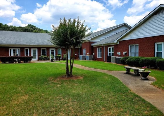Outdoor view of Magnolia Estates facility with gardens and walkways