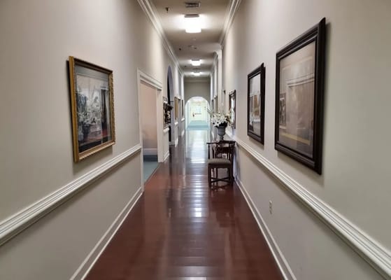 A well-lit corridor with framed artwork