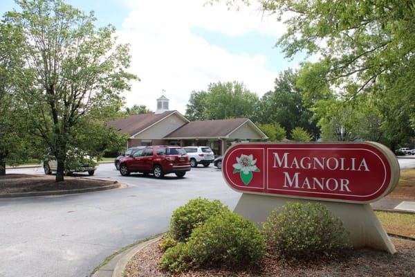 Exterior view of Magnolia Manor with facility sign