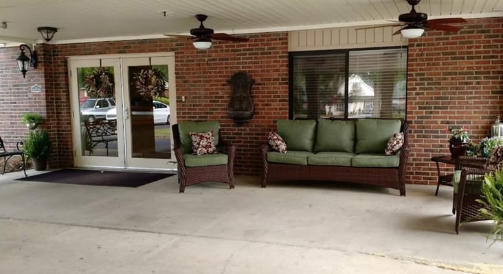 Outdoor seating area with green couches and fans