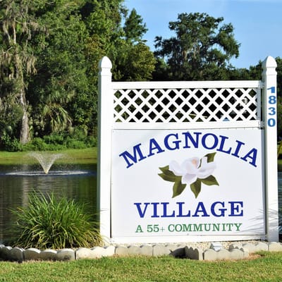 Sign for Magnolia Village community by the pond