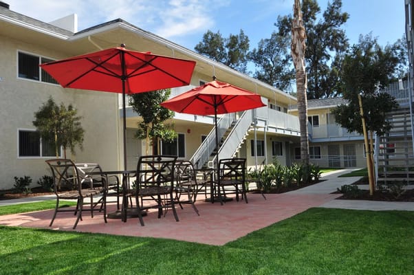 Red umbrellas over seating in a courtyard area