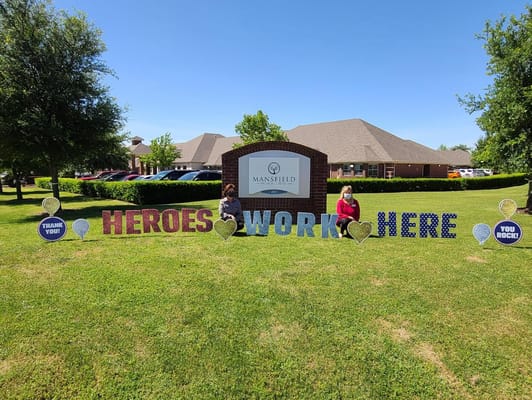 Residents posing with a sign outside the facility