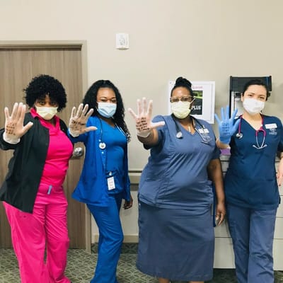 Staff members showing their decorated hands with masks on