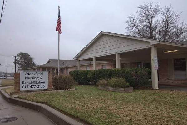 Front view of Mansfield Nursing and Rehabilitation facility with American flag.