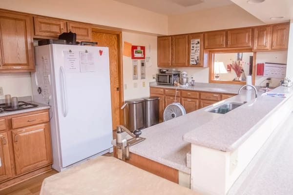 Bright kitchen area with wooden cabinets and appliances