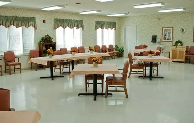 Spacious dining room with tables and chairs, decorated with flowers.