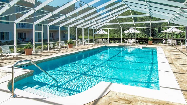Bright indoor pool area with lounge chairs