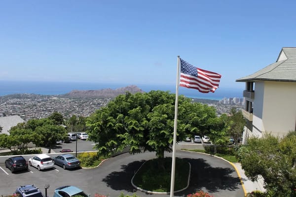 American flag waving with Honolulu in the background