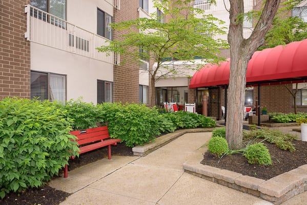 Entrance to the garden area with red bench and covered seating