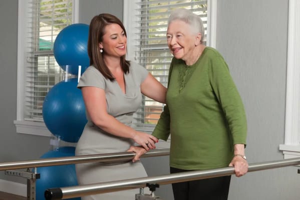 Therapist assisting a senior resident in an activity room